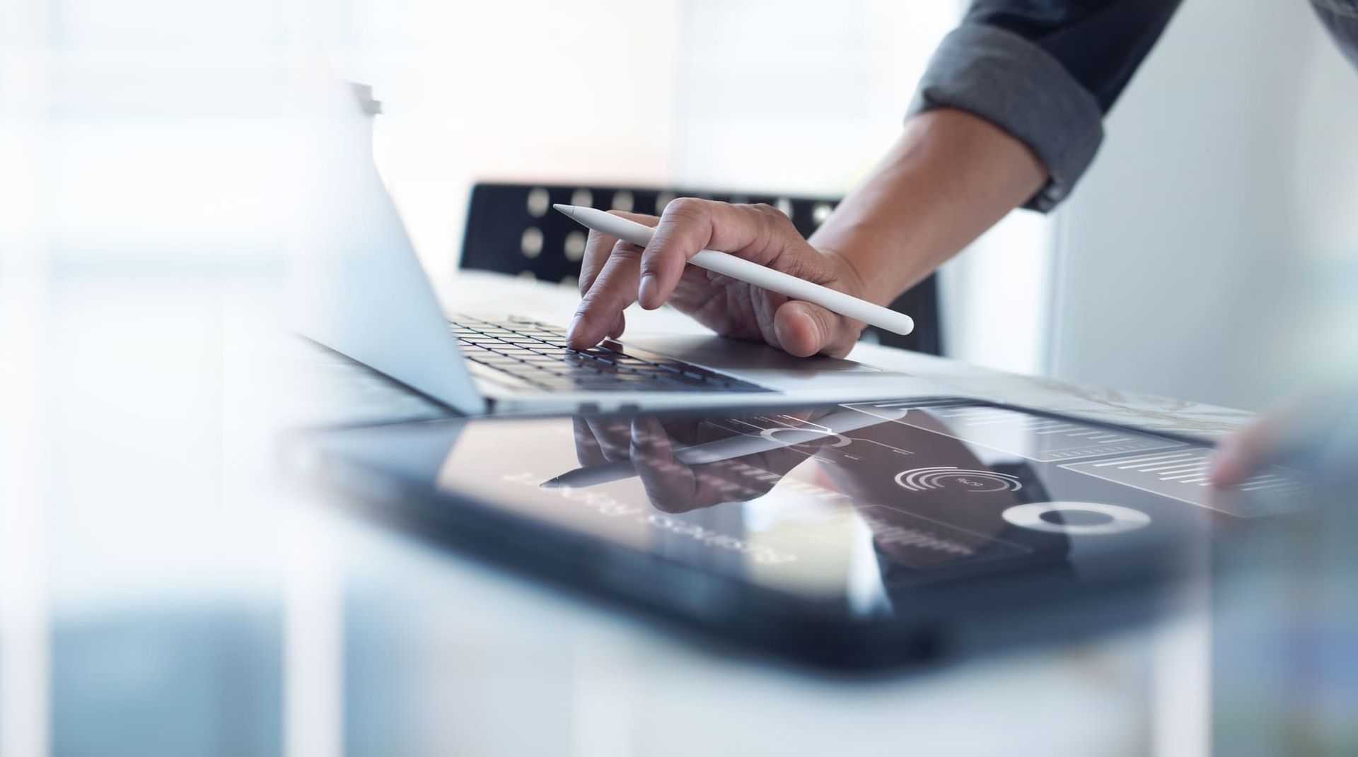 Mann klickt auf IPad und Computer herum